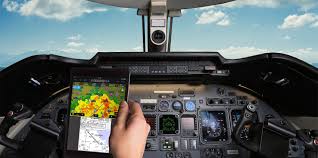 Aircraft cockpit with modern avionics displays and ADS-B flight tracking interface.