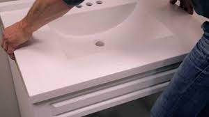 If the cabinet has no back, simply attach it to the wall so it encloses the plumbing. Rona How To Install A Bathroom Vanity Youtube