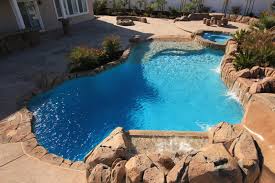 Geometric vanshing edge pool sports two sunshelfs, two fire bowls, and a spa all finished with npt stonescapes midnight blue mini pebble and a touch of glass. Pool Finishes Paradise Custom Pools