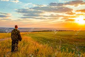 Human And Nature A European Man Stands In A Field Looking Into The Distance To The