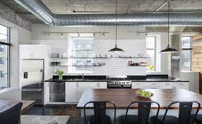 The white walls, stainless steel cabinets, bright window, and mirror all contribute to the illusion of more space. New York Loft Kitchens Kitchen Magazine