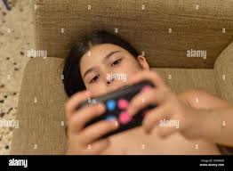 Young girl plays video games with a handheld game console Model released  Stock Photo - Alamy