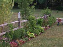 A simple farmhouse with low maintenance landscaping including a well aged split rail fence no more than 3 feet high. Exterior Design Cool Split Rail Fence For Yard Railing Ideas Garden Fencing Fenced Vegetable Garden Fence Landscaping