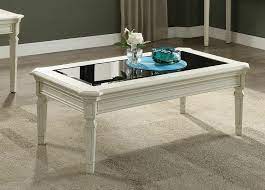 Crafted for the incredible kress collection, this glass accented coffee table boasts a daring stark white finish with contrasting walnut legs with ample character to offer. Acme United Acme 83090 Florissa Antique White Finish Wood Black Glass Insert Coffee Table