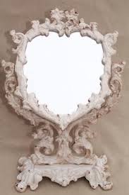 This is a large oval shaped cast iron vanity mirror with a swinging foot to stand on a table. Vintage Cast Iron Frame Mirror On Stand Heart Shape Vanity Mirror W Shabby Chippy Paint