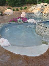Here, the white fiberglass pool liner is installed on the dark naturally finished deck. Beach Entry Pools Beach Entry Pools Beach Entry Pool Gunite Swimming Pool