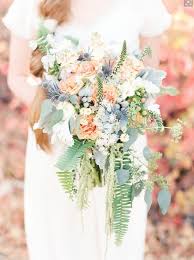 Whimsical fall bouquet with orchids, dahlias, roses and thistles. Gorgeous Peach Blue And Green Bridal Bouquet With Blue Thistle Sword Fern Veronnica Eucalyptus Hy Bridal Bouquet Blue Bridal Bouquet Peach Wedding Bouquet
