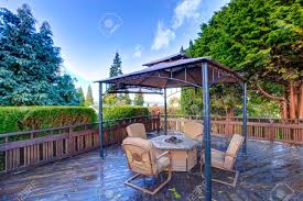 It's usually a shaded walkway or sitting area made of wooden posts and a cross section of beams. Wooden Deck With Railings And Gazebo With Fire Pit And Chairs Stock Photo Picture And Royalty Free Image Image 29422655