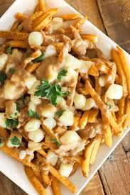 Poutine Is A Popular Dish Originating From Quebec It Is Canada S Version Of Smothered Fries Crispy Potato Fries Are Cove Poutine Recipe Recipes Canadian Food