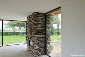 exclusieve binnenhaard bekleed met gereconstrueerd natuursteen haardbekleding van binnen naar buiten geopietra haar binnen buiten haarden haard natuursteen