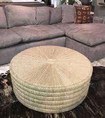 The tabletop is made from solid pine wood and has a butcher block style with visible wood grain and knots for a rustic, antique look. Round Pandan Rope Coffee Table Mecox Gardens