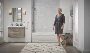 Brushed nickel shower head with digital shower valve, victoria and albert bathtub, curbless shower with hidden shower drain, flat pebble shower floor, shelf over tub with led lighting, gray vanity with drawer fronts, white square ceramic sinks, wall mount faucets. How To Remodel Your Bathroom With A Shower Tub Bathwraps