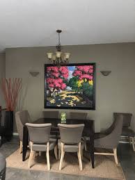 It has a wooden dining table and gray tufted chairs over hardwood flooring. Pot Lights Over Dining Room Table