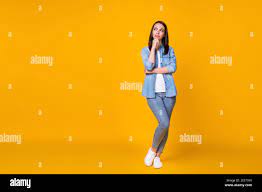 Full size photo of minded girl touch hand chin look copyspace think  thoughts decide decision wear casual style clothes sneakers isolated over  vivid Stock Photo - Alamy