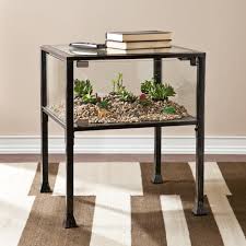 An antique black finish and dark antique bronze detail give this beautiful piece a cultured style. Upton Home Display Terrarium Side End From Overstock
