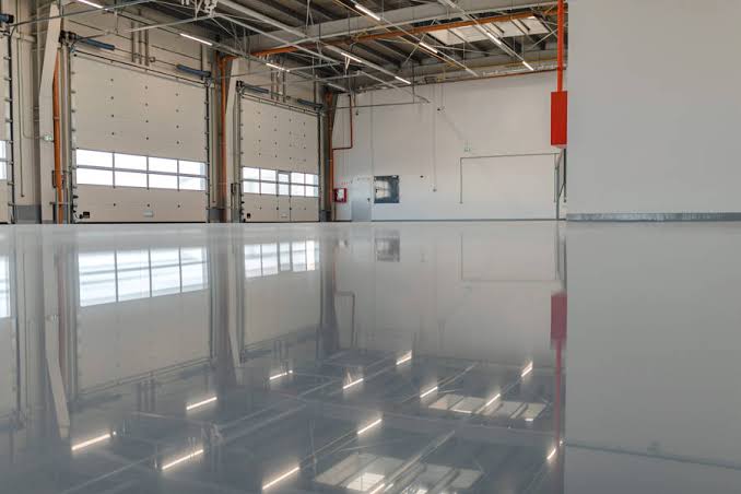 Sol époxy industriel gris brillant dans une usine moderne — revêtement professionnel