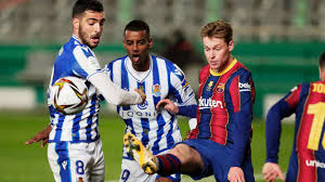 Barcelona toca a bola na sua área defensiva e a real sociedad tenta apertar. Dqjrbd72m8dypm