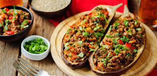 Después la cortamos a lo largo una vez esté caliente, añadimos los dientes de ajo, la cebolla y el pimiento rojo bien picados. Berenjenas Rellenas Ideas Para Preparar Esta Receta