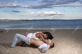 Sex On Beach Concept. Couple In Love Have Sex, Makes Love On Sand Beach.  Couple Full Of Desire Have Sex On Sand Of Seashore. Sensual Lovers Making  Love At Seashore, Sea On