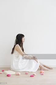 Young Woman Sitting On Floor And Daydreaming