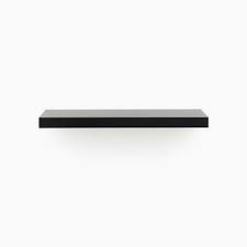 A floating fireplace mantel appears to be protruding directly from the wall without any legs or brackets supporting it. Aksel Premium Black Floating Shelf Minimal Modern Gorgeous