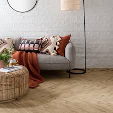 The majorly white kitchen is cleverly sandwiched between the living room and dining area that is dominated by brown tones. Klarity Tiles Topps Tiles