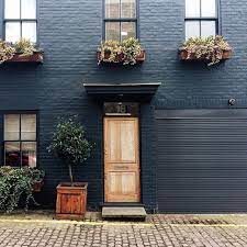 Modern black painted brick house. How To Paint Brick Definitive Guide Domino Brick Exterior House Painted Brick Exteriors Painted Brick House