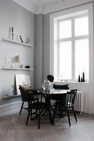A Round Dining Table In The Corner Of An Open Plan Living Space With High Ceilings Round Dining Room Sets Round Dining Room Table Dining Table Black
