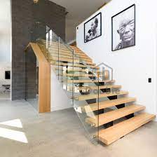 This modernised farmhouse staircase design features warm wood tread, risers and newel posts, with the modern injection of clear glass panels. China Modern Stairs Design Glass Railing Wood Steps Staircase China Stair Glass Stairs