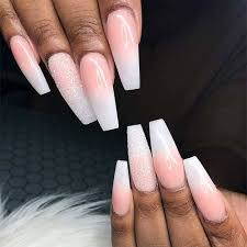 Stylish Belles Long Glossy Pink To White Coffin Ombre Nails Long Beauty delicate hands with manicure holding pink flower close up.