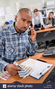 Man On Telephone Holding Colour Charts Looking Confused
