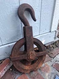 An antique wooden pulley and hook hoist system that was pulled from an old ship. Vintage Chain Hoist Pulley Antique Cast Iron Wheel Pulley Large Wheel Industrial Decor Heavy Duty Rope P Pulley Decor Antique Cast Iron Pulley Decor Ideas