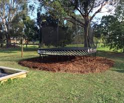 Placing a synthetic grass mat underneath creating an area of gravel to place your trampoline mulching an area of your lawn Trampoline Man
