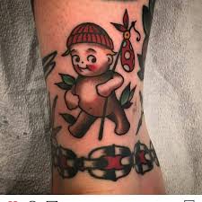 Grey ink cherub in clouds with roses tattoo on male shoulder. Cherub Tattoo All Things Tattoo