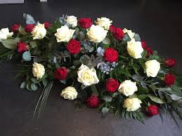 Bouquet with white funeral flowers as lily. Red White Roses Coffin Top Scentiments Flowers
