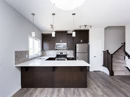 A Beautiful White Kitchen With Dark Brown Cabinets Gray Floors And Lovely Backsplash Perfect F Dark Brown Cabinets Dark Brown Kitchen Cabinets Grey Flooring