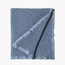 Pink and navy blue abstract painting on a gray wall with molding in an elegant dining and living room. Hotel Luxury Collection Lisa Navy Blue Or Light Petrol Blue Cotton Waffle Blankets