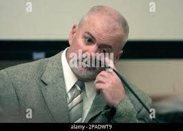 Fort Collins, Colo. Police officer Neal Hisam holds up a head board with  ropes attached that he had collected as evidence during the trial of William  Hunsaker at the Larimer County Justice