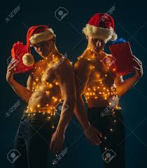 Festa De Natal E Jogos De Sexo. Gêmeos Santa Com Corpo Muscular Na Festão.  Faixa De Ano Novo E Presentes Para Adultos. Homens Novos No Traje De Santa,  Atual Para Meninas. Chame