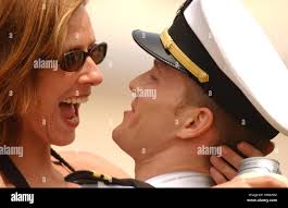 US Navy Lt. hugs his wife at the Naval Air Facility Atsugi, Japan after  returning from a four-month deployment aboard USS Kitty Hawk (CV 63 Stock  Photo