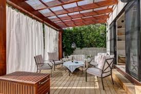 Holzpergola Mit Sonnenschutz Gardinen Aus Lichtundurchlassigem Stoff Holzpergola Terrassenuberdachung Gartengestaltung