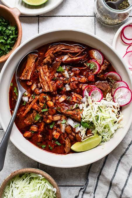 Family enjoying pozole rojo together at a festive Mexican dinner table