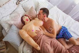 Top View Of Happy Naked Man Lying On The Bed And Caresses Rubber Sex Doll.  Stock Photo, Picture And Royalty Free Image. Image 68507094.