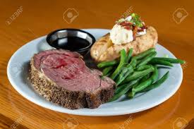 Prime Rib Meal Served On A Plate With A Loaded Potato And Green Beans With A Side Of A Jus Stock Photo Picture And Royalty Free Image Image 112043738