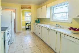 Yellow And White Kitchen In A Cozy Tacoma Wa Craftsman Tile Floors And Lots Of Craftsman Kitchen Cabinets White Craftsman Kitchen Cabinets Craftsman Kitchen
