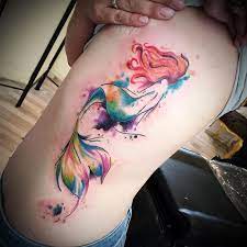 This tattoo uses a simple and minimal design to depict ariel and flounder. Mermaid Sticktoyourskintattoo Sticktoyourskin Coburg Eternalink Aquarelltattoo Watercolor Arielle R Mermaid Tattoos Tattoos Watercolor Mermaid Tattoo