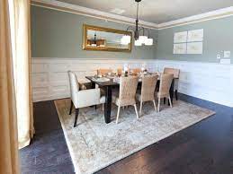 It has a dark wood dining set fitted with white cushions along with a pair of brown it has a wooden dining table surrounded by leather and green skirted chairs. Green Dining Room With Understated Elegance Hgtv