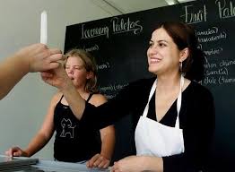 Irma Paz, co-owner of Las Paletas, sells a lime paleta to a customer July  31, 2002. Paz sells over 100 paletas a day at their 12th Avenue South  store.” — Although starting