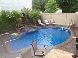 Backyard swimming pool with island. Pools Staten Island Ny Landscaping Asphalt Paving Exterior Design Pool Patio Construction Brick Pavers And Pvc Fencing Contractors Advanced Site Contractors