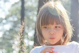long haired girl in white shirt glancing to her left side by Christine  Blaylock. Photo stock